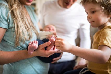 Happy family gathered around baby