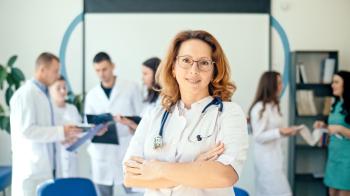 Smiling doctor with several other doctors behind her