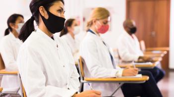 Mask wearing woman in a class full of students