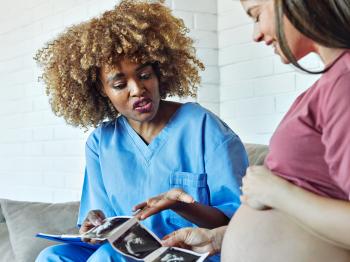 Healthcare working reviewing ultrasound with pregnant patient